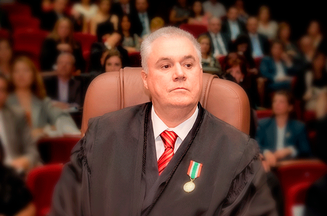Foto horizontal: desembargador Fernando Boller veste toga e medalha institucional durante solenidade no Tribunal de Justiça de Santa Catarina, diante de plateia reunida em auditório.