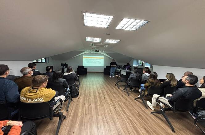 Foto horizontal: participantes acompanham apresentação durante curso de capacitação em sala de treinamento, com exposição de conteúdo técnico e atividades voltadas ao aperfeiçoamento profissional.