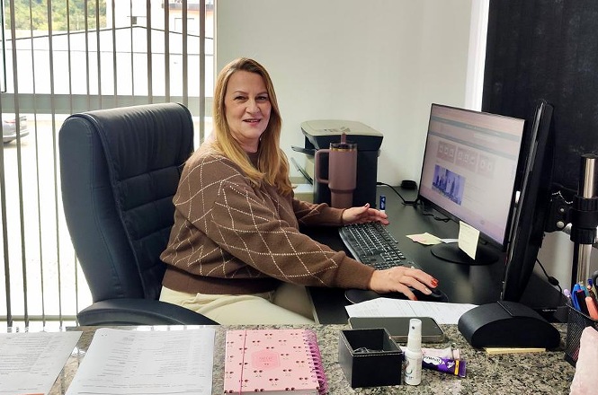 Foto horizontal: servidora trabalha em computador em ambiente administrativo do Poder Judiciário de Santa Catarina.