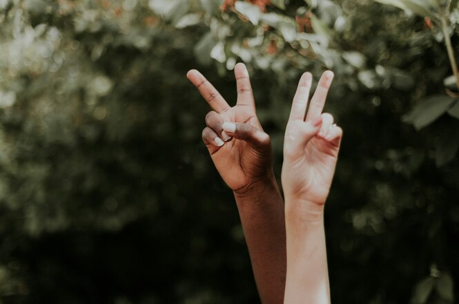 Foto ilustrativa: mãos de pessoas com diferentes tons de pele fazem gesto de paz, simbolizando diversidade, inclusão, respeito, união e convivência.
