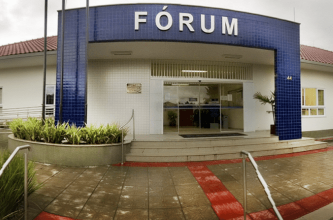 Foto horizontal: fachada do Fórum da comarca, com entrada principal, escadaria, rampa de acessibilidade e piso tátil.