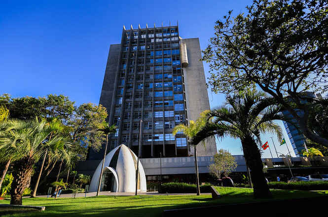 Foto horizontal: edifício-sede do Tribunal de Justiça de Santa Catarina, visto da área externa, com jardins e monumento em primeiro plano.