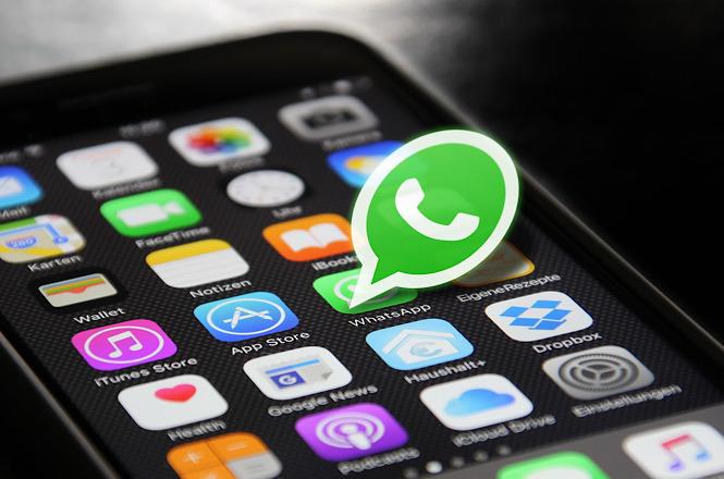 Foto horizontal: tela de smartphone exibe o aplicativo WhatsApp em destaque entre outros ícones, representando comunicação digital.