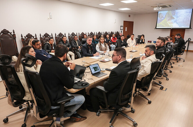 Foto horizontal: magistrados, servidores e representantes de instituições participam de reunião técnica em torno de mesa de trabalho, durante debate sobre ações e projetos institucionais do Poder Judiciário.