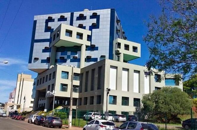 Fachada do Fórum da comarca de Chapecó, com arquitetura moderna e prédios ao redor.