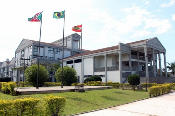 Fachada do Fórum , com jardim frontal, colunas e mastros das bandeiras.