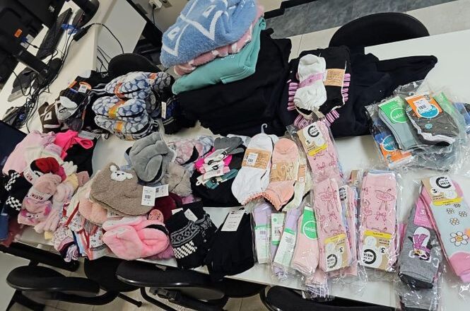 Mesa reúne roupas, meias, cobertores e itens de inverno arrecadados para campanha solidária.