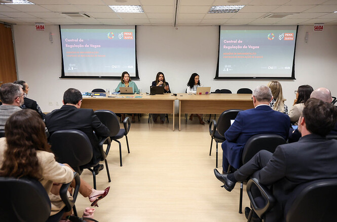 Foto horizontal: Autoridades acompanham apresentação sobre a Central de Regulação de Vagas durante encontro do programa Pena Justa.