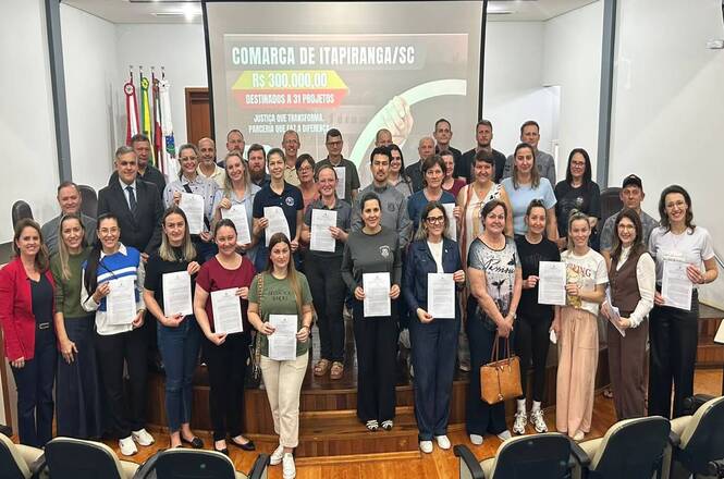 Foto horizontal: participantes do programa Justiça Terapêutica posam com certificados durante solenidade