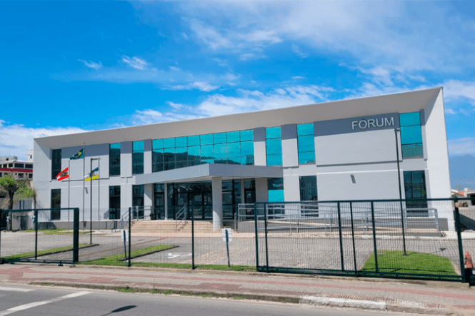 Foto horizontal: fachada do Fórum com arquitetura contemporânea, fachada envidraçada e acesso principal ao edifício.