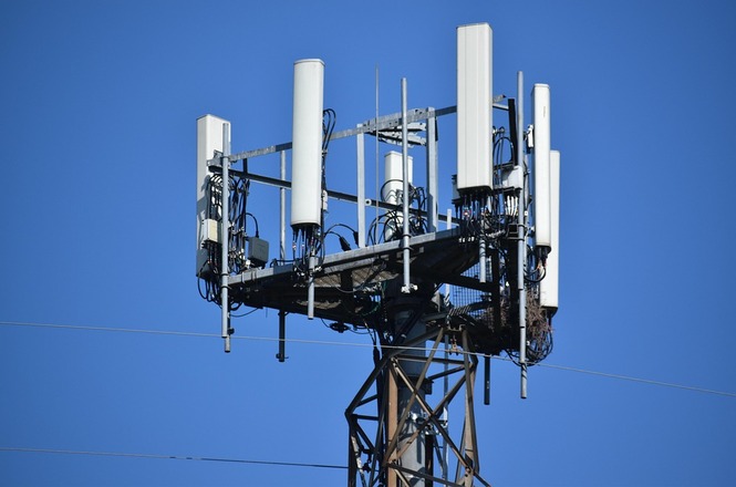 Foto horizontal: Antena de telecomunicações instalada em torre metálica, utilizada para transmissão de sinais de telefonia móvel.