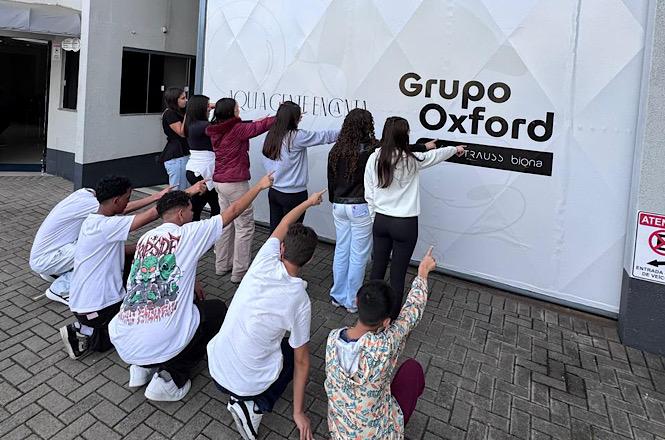 Foto horizontal: Jovens participantes de projeto social visitam empresa parceira durante atividade de integração ao mercado de trabalho.