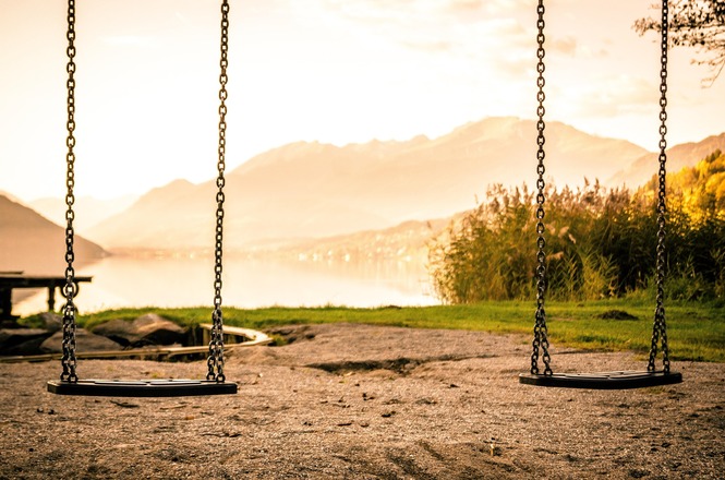 Foto horizontal: Balanços vazios em parque simbolizam infância, ausência e a importância da proteção de crianças e adolescentes.