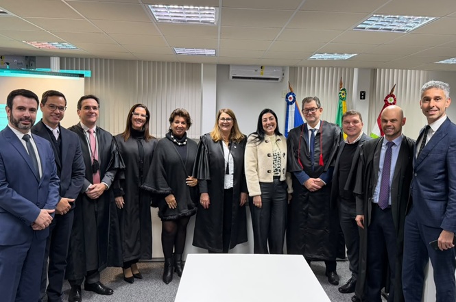 Foto horizontal: magistrados e servidores reunidos para registro coletivo após atividade institucional.