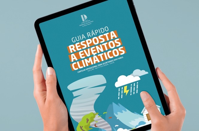 Foto horizontal: mãos seguram tablet que exibe guia rápido sobre resposta a eventos climáticos.