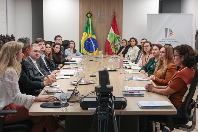 Imagem horizontal mostra autoridades reunidas em torno de mesa durante reunião no Tribunal de Justiça de SC.