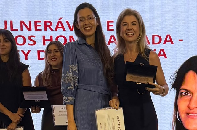 Imagem horizontal mostra servidora do TJSC sorrindo ao receber menção honrosa e certificado em premiação nacional.