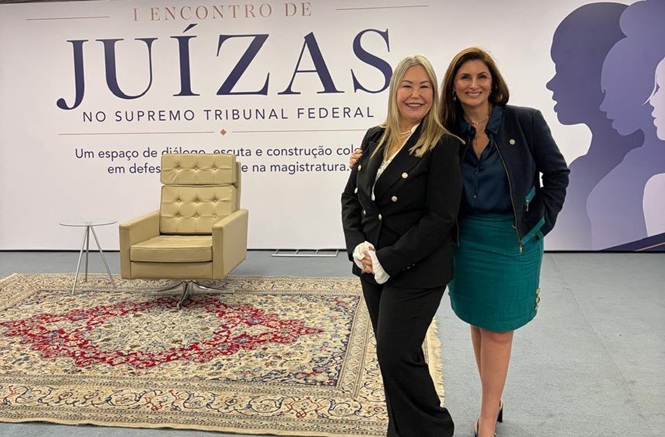 Foto horizontal: desembargadoras Denise, de calça e blazer pretos, e Érica, de blazer preto e saia verde, posam no I Encontro de Juízas.