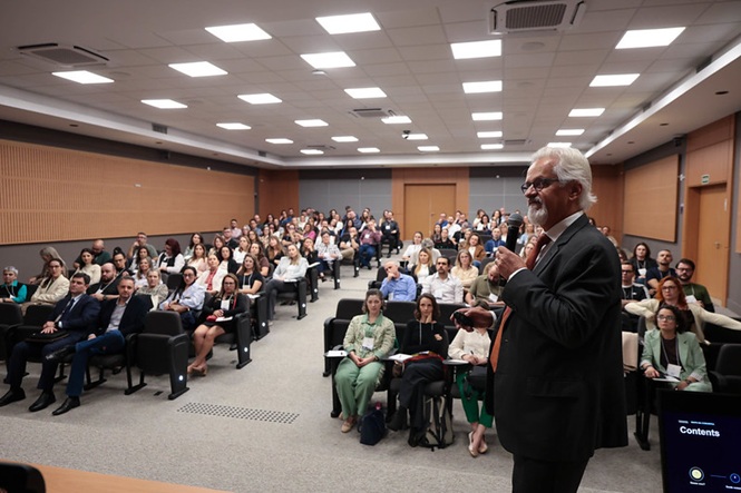 Foto horizontal: Jaime Nogueira da Gama, mestre em Gestão Empresarial e em Administração, fala ao microfone diante do público em auditório.