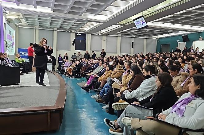 Foto horizontal: desembargadora Hildemar Meneguzzi fala ao microfone diante de público reunido em auditório.