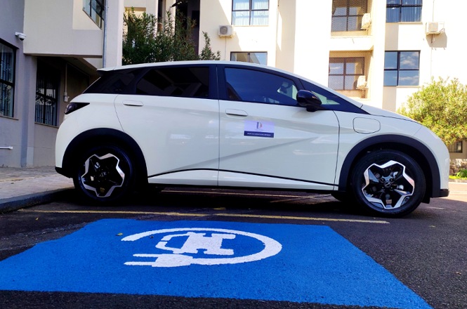 Foto horizontal: veículo branco do Poder Judiciário estacionado sobre vaga azul destinada a pessoas com deficiência.