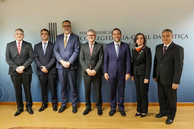 Foto horizontal: grupo de seis integrantes do Poder Judiciário posa lado a lado, em ambiente institucional da Corregedoria-Geral da Justiça.