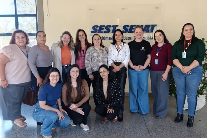 Foto horizontal: grupo de 11 mulheres posa em frente à unidade do Sest Senat, algumas em pé e outras agachadas.