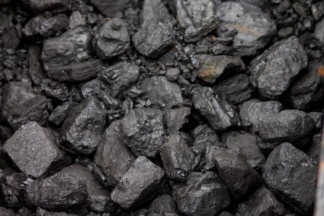 Foto horizontal: close de pedaços de carvão mineral, em diferentes tamanhos, com tonalidades entre preto e cinza-escuro.