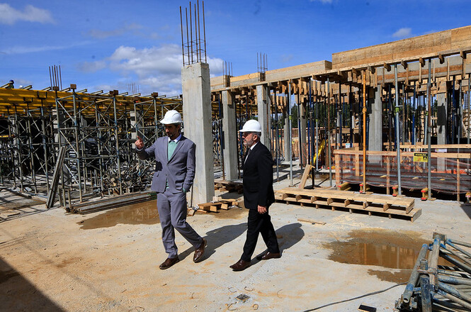 Foto horizontal: pres. do TJSC, des. André Luiz Dacol, de terno preto e capacete branco, acompanha visita à obra.