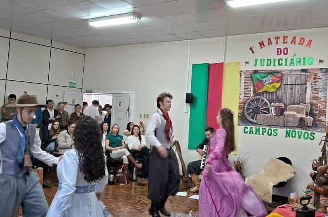 Foto horizontal: apresentação cultural reúne dançarinos com trajes gaúchos na 1ª Mateada do Judiciário, em Campos Novos.