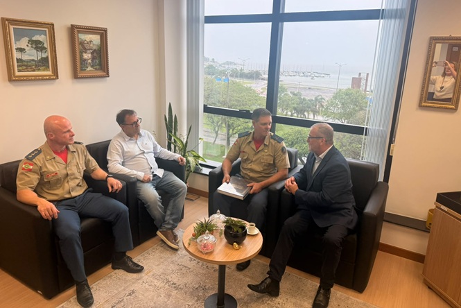 Foto horizontal: desembargador Altamiro de Oliveira conversa com comitiva do Corpo de Bombeiros em escritório do TJSC.