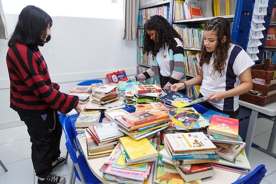 Jovens escolhem livros doados a Centro Educacional de Itajaí.