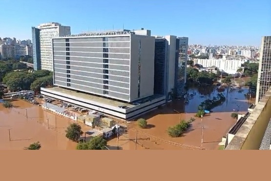 Foto tirada de um ângulo de cima que mostra os arredores de um prédio durante a enchente.